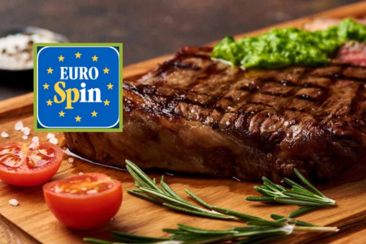 carne su un tagliere con accanto pomodori e rosmarino