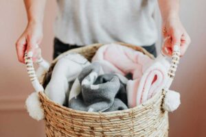 Donna che porta cesto con coperte