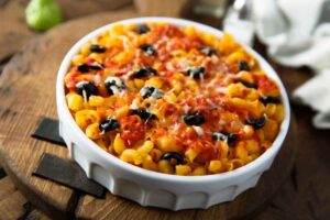 Piatto di pasta con sugo, olive nere e formaggio