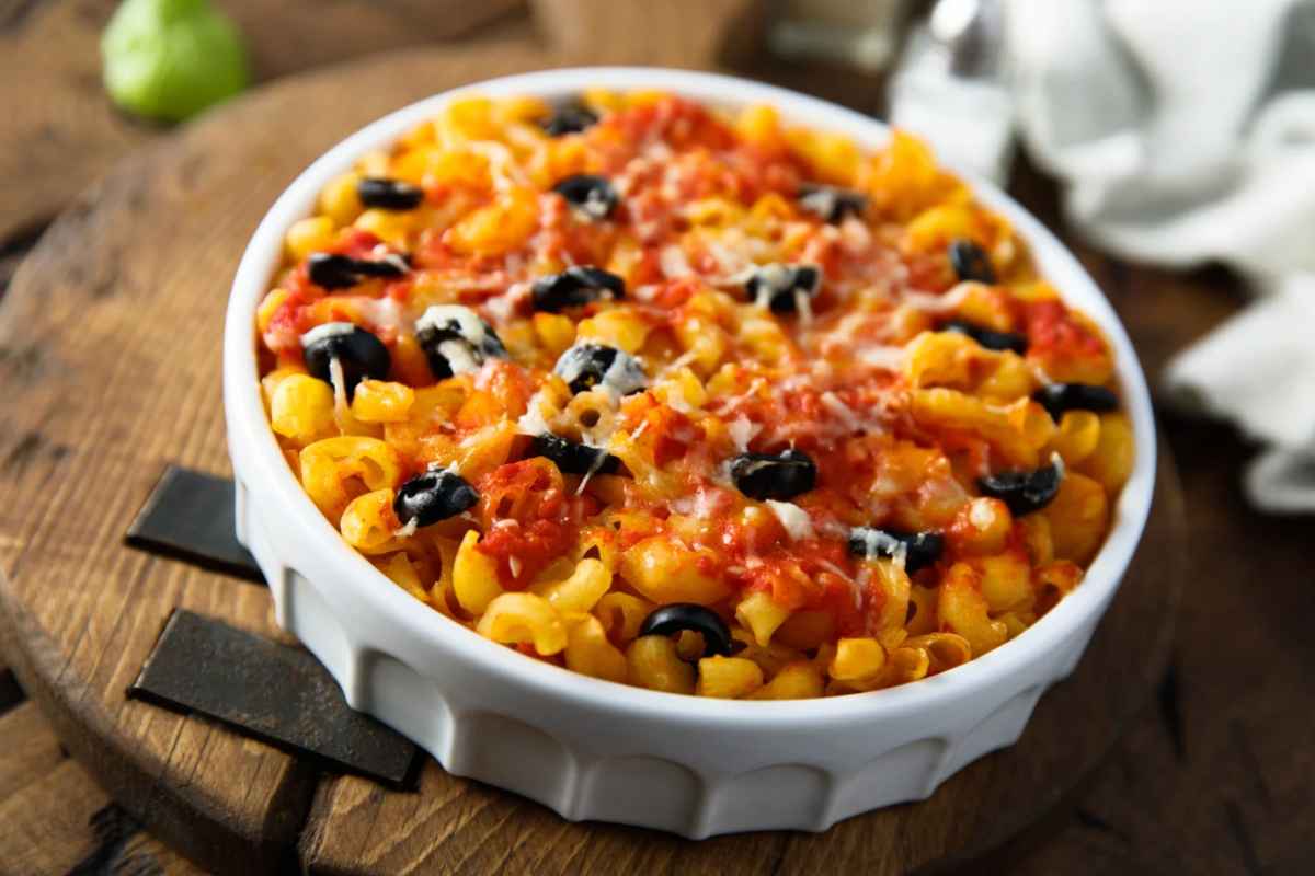 Piatto di pasta con sugo, olive nere e formaggio