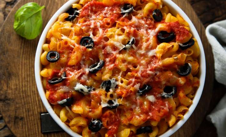 Piatto di pasta pasticciata con olive nere, formaggio e sugo